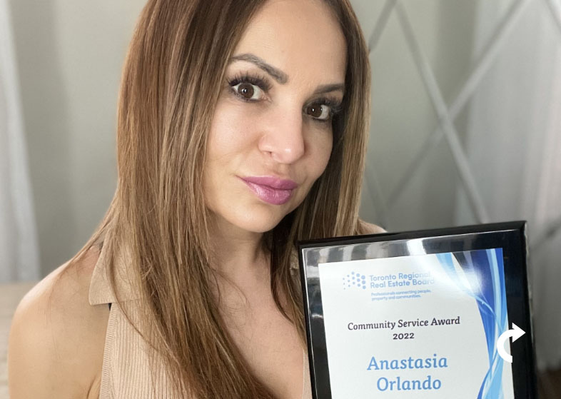 Anastasia Orlando smiling and holding her 2022 Community Service Award
