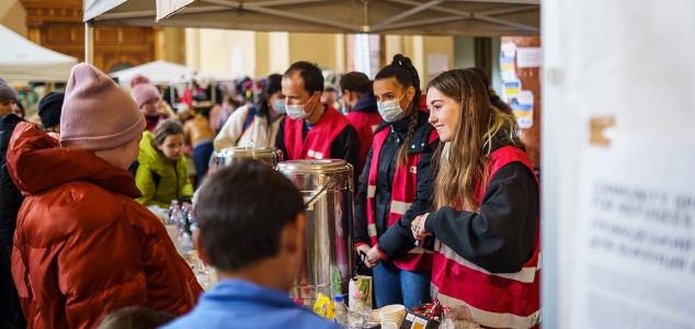 Group of people from the Red Cross serving hot drinks.